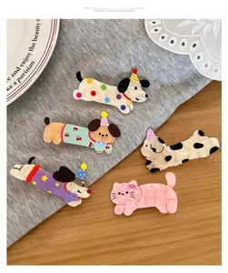 Detail shot of a 5-piece cartoon puppy and kitten hair clip set with party hats on wood table