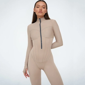 Détail du body beige avec fermeture éclair frontale, coutures galbantes et poignets passe-pouce
