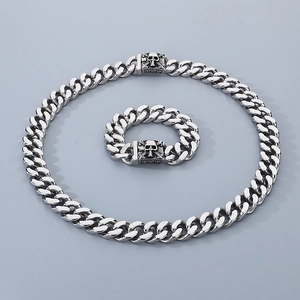Detail of silver skull relief on the square clasp of cuban link necklace and bracelet set