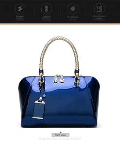 Detail of dark blue patent leather bag with gold hardware and woven metal handles
