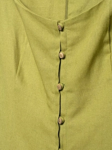 Dettaglio ravvicinato dell'abito in lino verde lime con bottoni tondi in legno