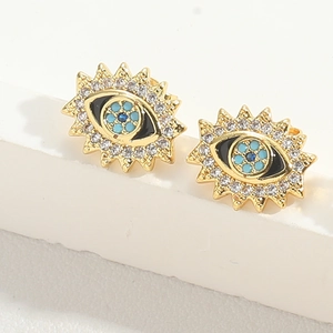 Detail view of gold Evil Eye stud earrings featuring white zircons and blue enamel inlay