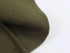 Macro shot of olive green ribbed knit fabric showing texture and stitching details