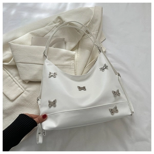 Dettaglio della borsa sottobraccio in pelle PU bianca con farfalle metalliche decorative