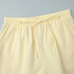 Gros plan détaillé de la taille élastique avec cordon sur le short jaune en lin