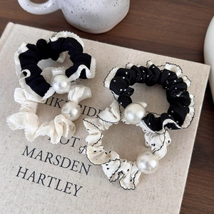 Polka dot and solid scrunchies with white faux pearls on a vintage book backdrop