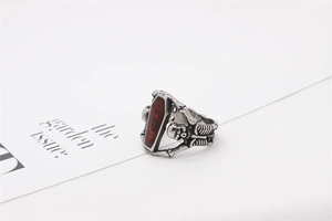 Detail of gothic punk ring showing silver mummy skull holding red enamel coffin