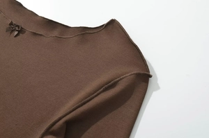 Close-up of brown knit dress featuring a delicate neckline and fine woven texture