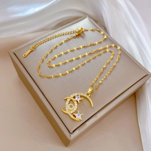 Detailed macro of gold star and moon pendant necklace with white zircon pavé setting