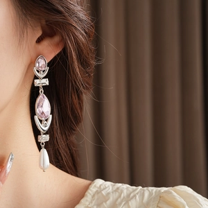 Detail view of drop earrings with pink teardrop crystals and elegant white pearls