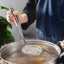 Close-up of a stainless steel fine mesh skimmer spoon filtering food from a hot soup pot
