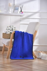 Detail of soft microfiber pet towel with paw prints hanging on a stylish wooden chair