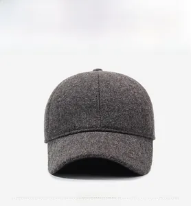 Close-up of a dark grey wool baseball cap with a subtle metal logo detail on the side
