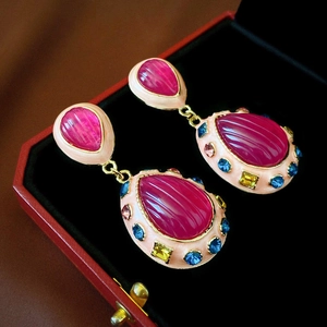 Close-up of vintage drop earrings with pink textured crystal and colorful rhinestones