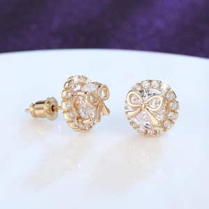 Macro view of gold-plated bow earrings featuring zircon stones and intricate micro-pave detailing