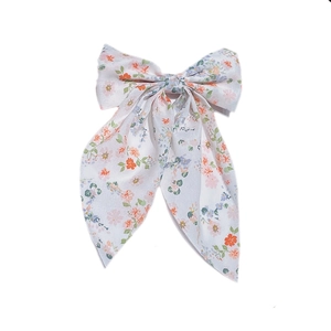 Floral bow hair clip with ribbons featuring delicate pink and orange flower patterns