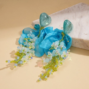 French vintage heart earrings with blue chiffon flowers and beaded tassels on marble