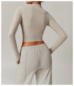 Detail view of back fit on stone grey high neck yoga top and slim fit joggers set