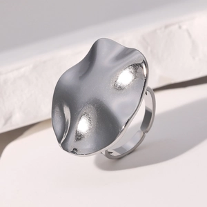 Close-up of irregular wave design ring with polished liquid texture on white stone
