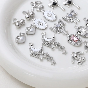Collection de pendentifs en alliage argenté cœur et nœud sur un plateau blanc pour DIY