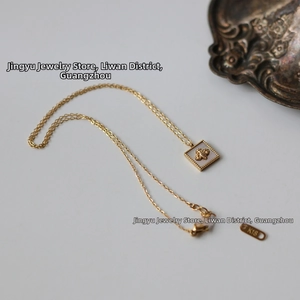 Detail of square bee pendant with white mother of pearl inlay on 18K gold plated chain