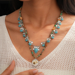 Detail view of layered Bohemian necklace with blue turquoise pendants and moon sun charms