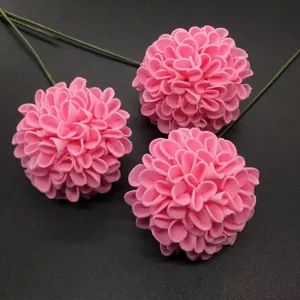 Detailed view of three pink artificial hydrangea flower heads on a textured gray background