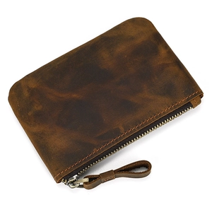 Detail view of brown genuine leather texture with vintage finish and metal zipper puller