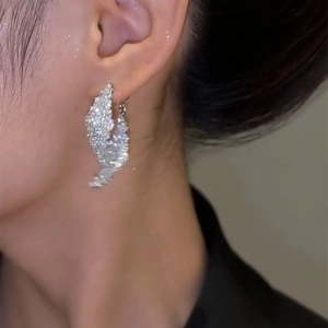 Elegant silver rhinstone twisted hoop earrings on model with sparkling finish