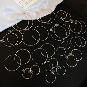 Collection de boucles d'oreilles créoles dorées et argentées sur fond de soie élégante