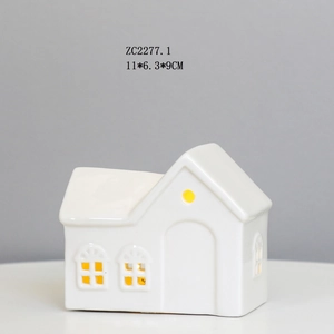 Macro view of white ceramic house LED night light with window cutouts and warm glow