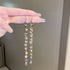 Detailed view of silver-tone tassel earrings featuring cascading round metal sequins