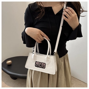 Detail of white crocodile pattern shoulder bag with pink letter embroidery logo