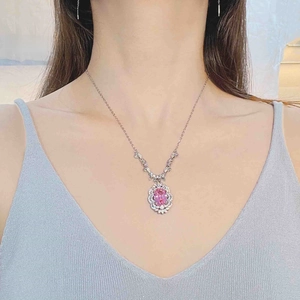 Close-up of elegant pink oval gemstone necklace with diamond halo worn by model