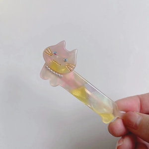 Detail of pink and yellow gradient cat hair clip with pearls and sparkling rhinestones