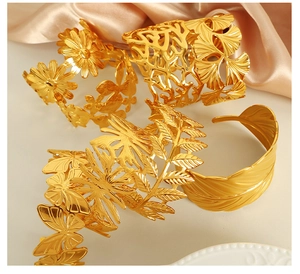 Detailed view of four golden titanium steel cuffs with floral and leaf cutout patterns