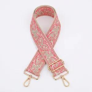 Close-up of bohemian paisley jacquard bag strap with gold metal hooks and buckle