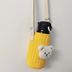 Detail of yellow quilted water bottle sleeve with plush bear and adjustable strap