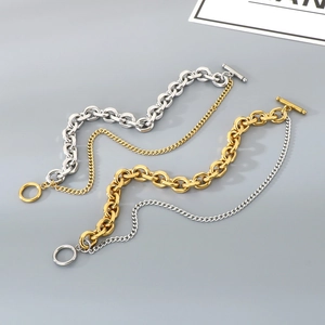 Detail of layered gold and silver hip-hop chain bracelets with decorative OT buckle clasp