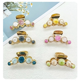 Flat lay showing six colorful metal hair clips with round resin and shell ornaments
