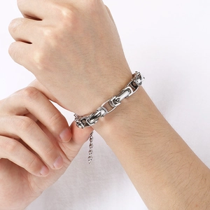 Gros plan d'un bracelet à maillons argentés avec une chaîne de réglage au poignet