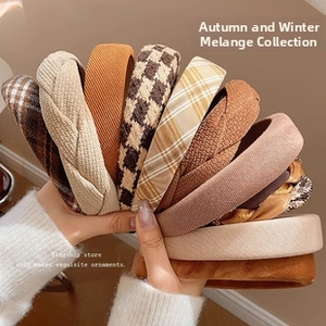 Detailed view of assorted wide knit and plaid fabric headbands in warm earthy tones