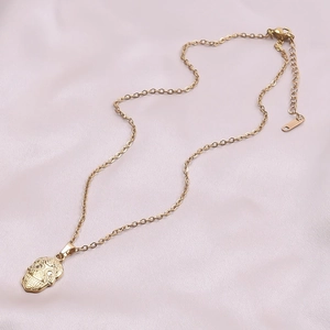 Detailed close-up of a 18k gold plated sugar skull pendant on a fine link chain necklace