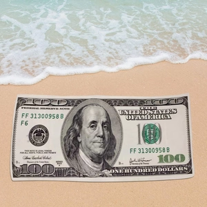 Detailed view of microfiber beach towel featuring a creative 100 dollar bill print on sand
