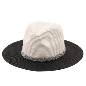 Detail of two-tone straw fedora with silver sequin band and woven texture on white background