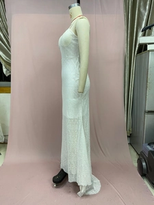 Detail view of white lace maxi dress showing intricate floral mesh and slim fit design