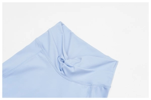 Dettaglio dei leggings da yoga azzurro a vita alta con un elegante design a nodo intrecciato