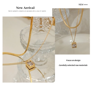 Detail of layered gold titanium necklace featuring a square zircon pendant and snake chain