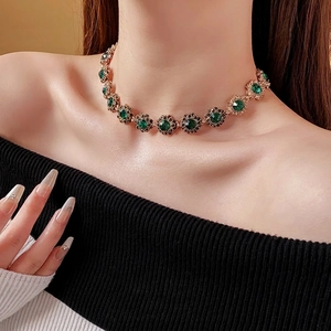 Vintage gold choker necklace with emerald green flower pendant and black accents
