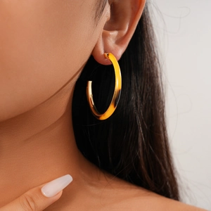 Primo piano di orecchini a cerchio a C placcati in oro 18K con texture in acetato ambrato
